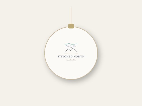 Mockup of a round white ceramic ornament with the Stitched North logo